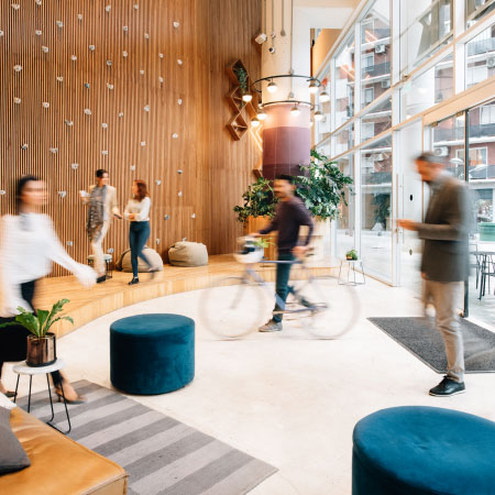 photo of a building lobby with person walking bicycle